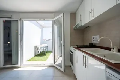 a kitchen with a sink and a sliding glass door at Apartamento Ciudad de las Ciencias con Terraza in Valencia