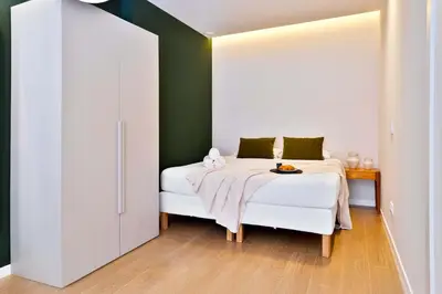 a bedroom with a white bed and a green wall at SariStays Valencia Modern & O in Valencia