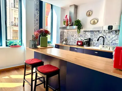a kitchen with a counter with two stools in it at Trendy Ruzafa Neighborhood - Spacious Luxury 3BR with Double Terrace in Valencia