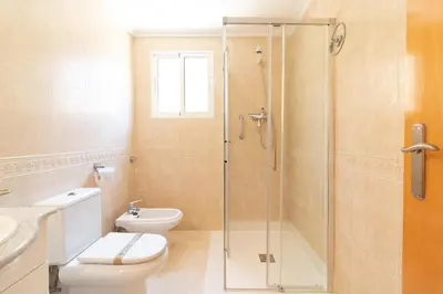 a bathroom with a shower and a toilet and a sink at Global Vacacional, Apartamento con terraza en la playa de Puerto Sagunto in Puerto de Sagunto