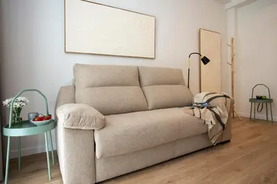 a couch sitting in a living room next to a table at Nomad Haux Zaidia in Valencia