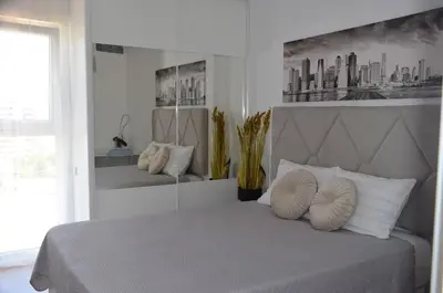 a white bedroom with a bed with two pillows at Fabuloso Piso Playa Canet de Bereguer Alquiler minimo 11 noches llamar al 64039uno856 in Canet de Berenguer