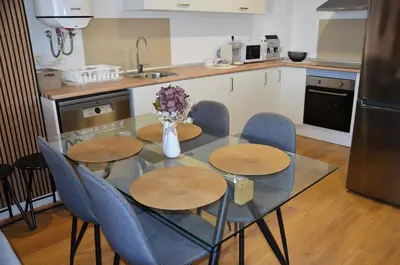 a kitchen with a table with chairs and a vase with flowers at Fabuloso Piso Playa Canet de Bereguer Alquiler minimo 11 noches llamar al 64039uno856 in Canet de Berenguer