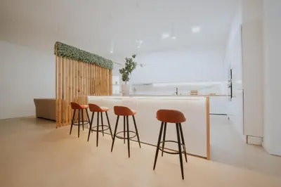 a kitchen with a counter with stools around it at Room Turia in Valencia