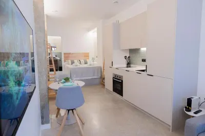 a kitchen with white cabinets and a table in a room at Blue City Apartments in Valencia