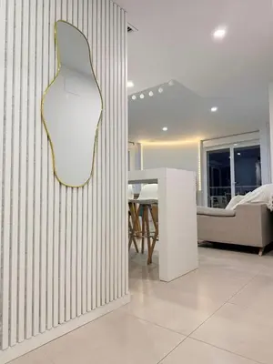 a living room with a white chair on a wall at Luxury Canet in Canet de Berenguer
