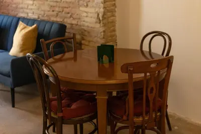 a wooden table and chairs in a room with a couch at Apartamento para 4 huespedes con Patio y ducha Exterior in Valencia