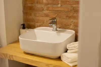 a white sink sitting on a wooden counter in a bathroom at Apartamento para 4 huespedes con Patio y ducha Exterior in Valencia