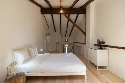 a bedroom with a white bed and a wooden floor at Apartamento2 para 4 huespedes con Patio y ducha Exterior in Valencia