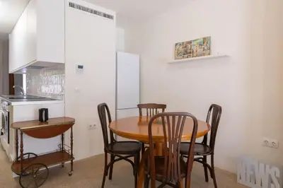 a kitchen with a wooden table and chairs in a room at Apartamento2 para 4 huespedes con Patio y ducha Exterior in Valencia