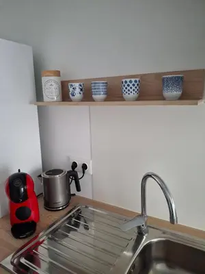 a kitchen counter with a sink and some cups on a shelf at Cullera Mar Azul in Cullera