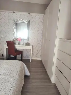 a bedroom with a bed and a desk and a mirror at Vacansis Cullera Pintor Sorolla 2 in Cullera