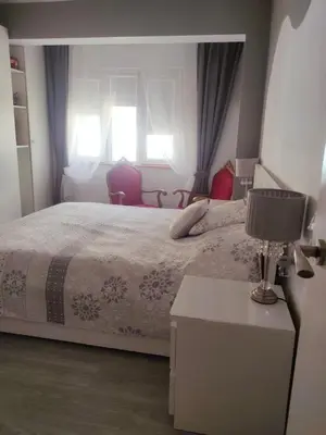 a bedroom with a bed and a table with a lamp at Vacansis Cullera Pintor Sorolla 2 in Cullera