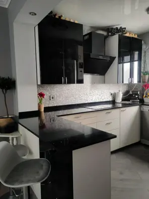 a kitchen with a black counter and white cabinets at Vacansis Cullera Pintor Sorolla 2 in Cullera
