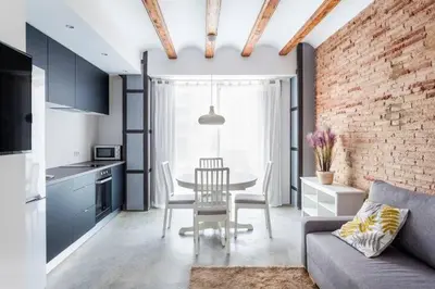 a living room with a table and a brick wall at Ruzafa Confort 3 pax wifi Denia 70 in Valencia