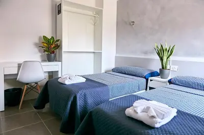 a room with three beds with towels on them at V Pension & Suites in Burriana