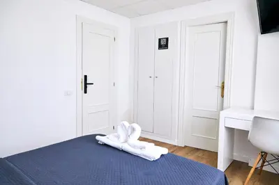 a bedroom with a bed with white towels on it at V Pension & Suites in Burriana