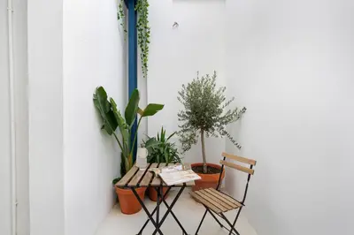 a table and two chairs with plants on a wall at Travel Habitat Playa del Cabanyal in Valencia
