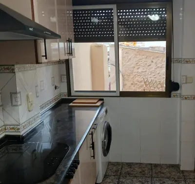 a kitchen with a sink and a washing machine at San Juan in Alborache