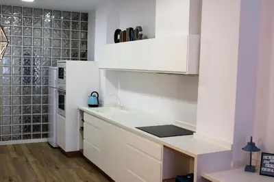 a kitchen with white cabinets and a sink at Playa Cabañyal - Diseño Mediterraneo in Valencia