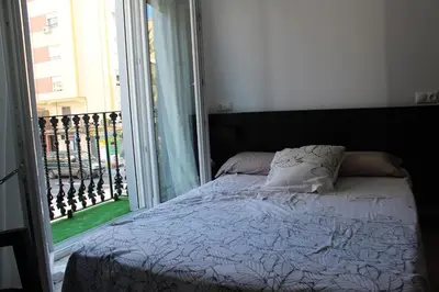 a bedroom with a bed and a large window at Playa Cabañyal - Diseño Mediterraneo in Valencia