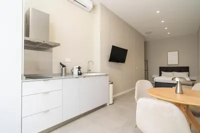a kitchen and dining room with a table and a bed at VLC Host - Sumsi Studios in Valencia