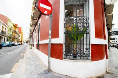 a red and white building with a sign on a street at LObjet trouvé in Valencia