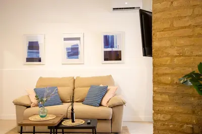 a couch in a living room with pictures on the wall at LObjet trouvé in Valencia