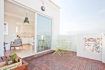 a kitchen and living room with a large sliding glass door at El Cabanyal - Mar y Atardecer in Valencia
