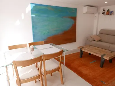 a living room with a table and chairs and a couch at Natural park, terrace and pool in Partida de La Cañada