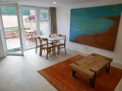 a dining room with a table and a painting on the wall at Natural park, terrace and pool in Partida de La Cañada