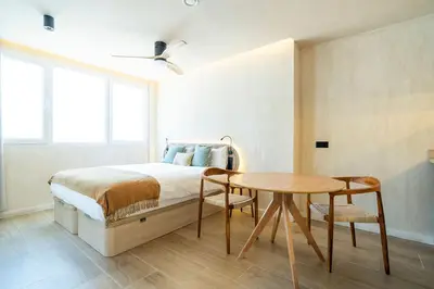a bedroom with a bed and a wooden table at Nomad HAUX Puerto in Valencia