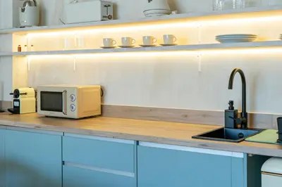 a kitchen counter with a microwave and a sink at Nomad HAUX Puerto in Valencia