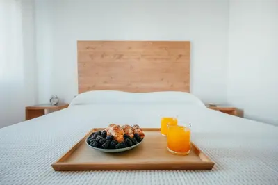 a tray with a plate of food and two glasses of orange juice at Garden at 50m from beach, ChillOut, Large Porche in Mareny Blau