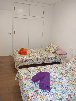 a room with three beds with a purple shirt on them at Apartament El Colomer 3 habitacions in Simat de Valldigna