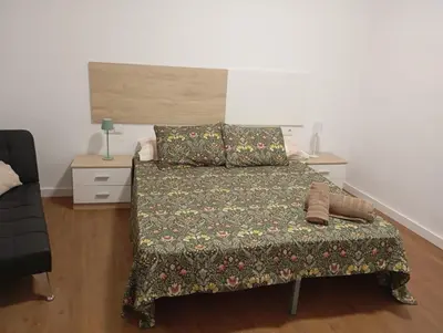 a bedroom with a bed with a green comforter at Apartament El Colomer 3 habitacions in Simat de Valldigna