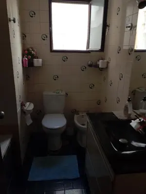 a bathroom with a toilet and a sink and a window at Habitación confortable in Valencia