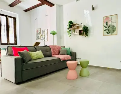 a living room with a couch with colorful pillows at Cute & Cozy Aparment Near The Historic Center in Valencia