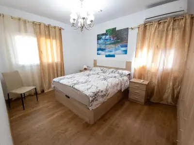 a bedroom with a bed and a chandelier at Casa Rustica en Las MONTAÑAS in Tales