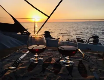 two glasses of wine sitting on a table on a boat at Magnificent sailboat with free parking for cars in Valencia