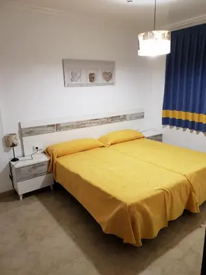 a bedroom with a bed with a yellow blanket at Complejo Turistico la Pinada in Gilet