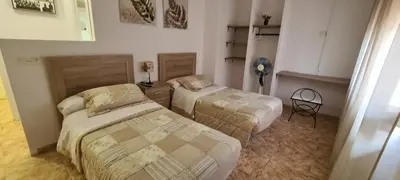 a bedroom with two beds and a chair in it at Complejo Turistico la Pinada in Gilet
