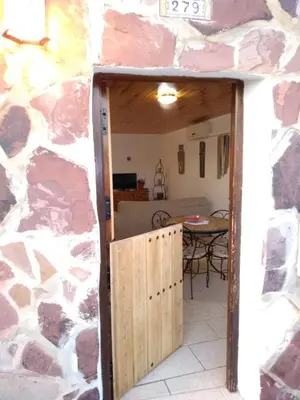 a door into a room with a stone wall at Les Eres de Gátova in Gátova