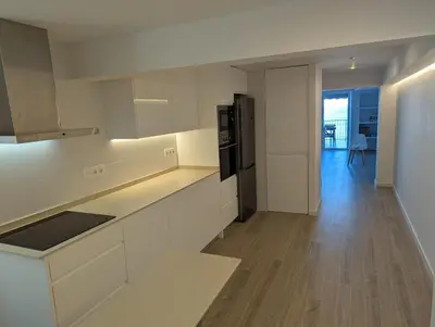 a kitchen with white cabinets and a black refrigerator at Apartamento en Primera Línea in Cullera