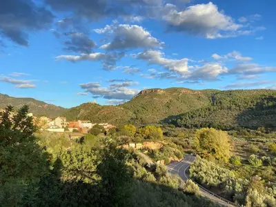 a road in the middle of a valley with mountains at Your stylish retreat in Sierra Espadán in Vall de Almonacid