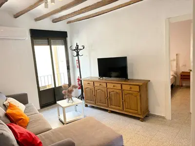 a living room with a couch and a tv on a wooden cabinet at Your stylish retreat in Sierra Espadán in Vall de Almonacid