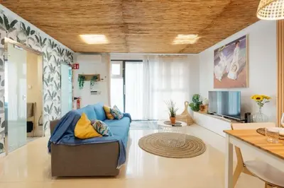 a living room with a blue couch and a kitchen at Tiny Valencia Gem - 2BR - Relax in Valencia