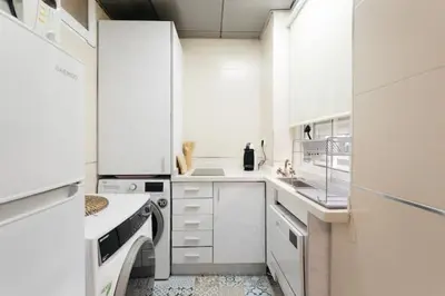 a white kitchen with white cabinets and appliances at Tiny Valencia Gem - 2BR - Relax in Valencia