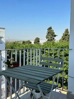 a green bench sitting on a balcony with a railing at Abadesa Apartments in Benetúser
