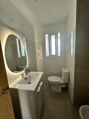 a white bathroom with a sink and a toilet at Abadesa Apartments in Benetúser